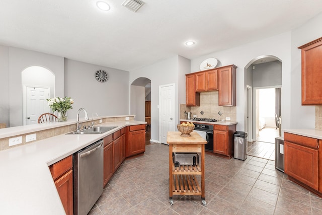 kitchen featuring a sink, stainless steel appliances, visible vents, arched walkways, and light countertops