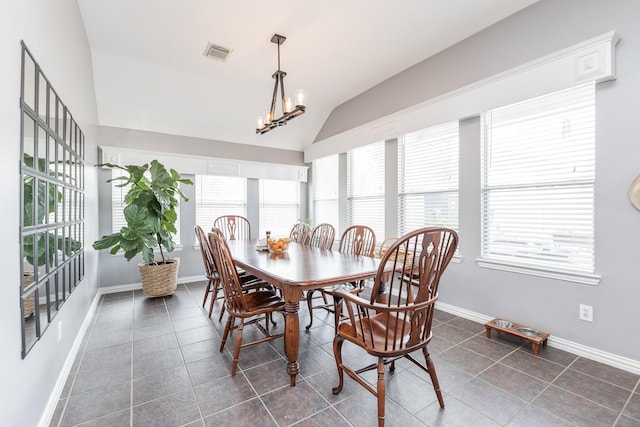 dining area featuring dark tile patterned flooring, vaulted ceiling, baseboards, and visible vents