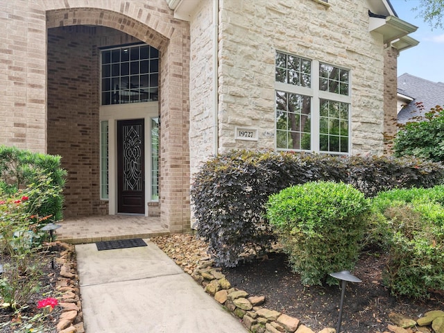 property entrance with brick siding and stone siding