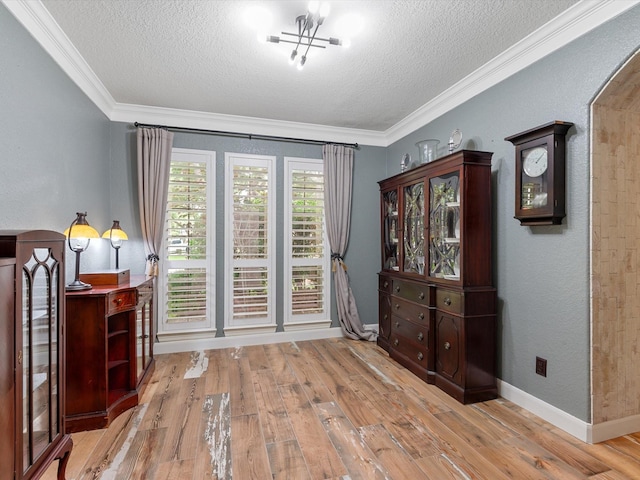 doorway with ornamental molding, hardwood / wood-style floors, a textured ceiling, and arched walkways