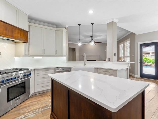 kitchen featuring a center island, a sink, stainless steel appliances, tasteful backsplash, and ornamental molding
