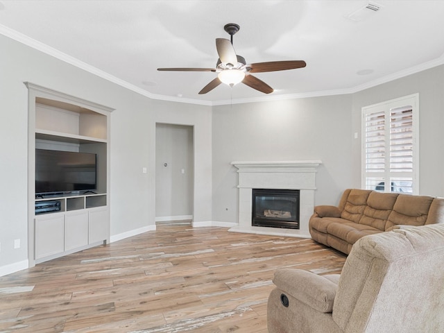 living room featuring ornamental molding, baseboards, light wood-type flooring, and built in shelves