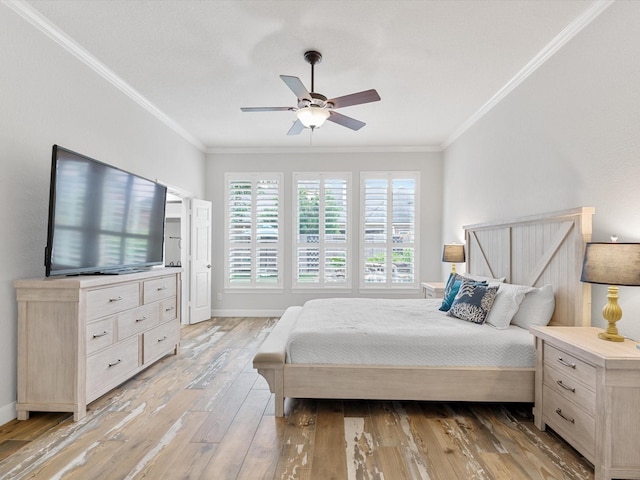 bedroom featuring crown molding, baseboards, light wood-type flooring, and a ceiling fan
