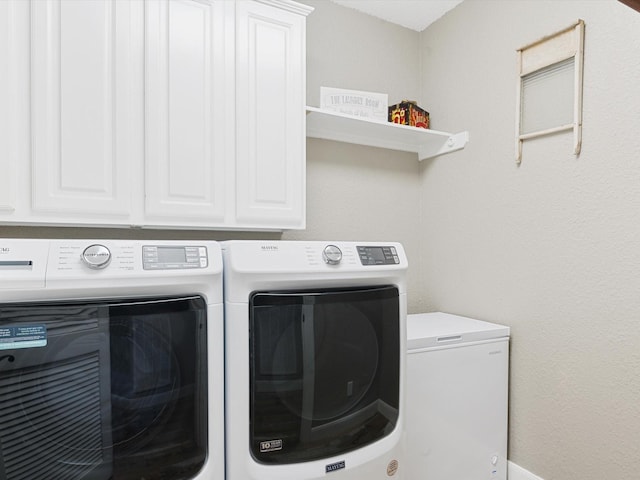 washroom featuring cabinet space and washing machine and clothes dryer