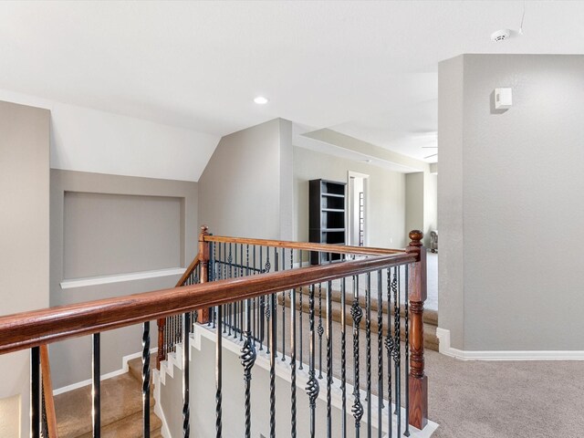 corridor with carpet flooring, an upstairs landing, baseboards, and recessed lighting