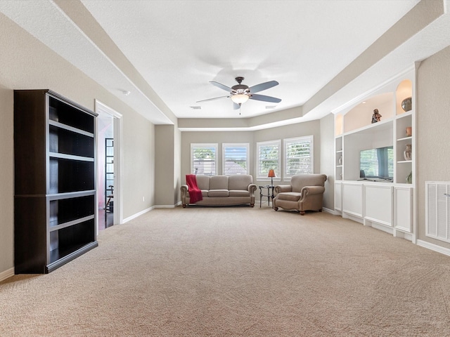 carpeted living area with a ceiling fan, baseboards, and visible vents