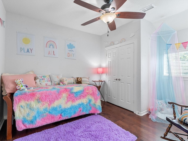 bedroom with a closet, a ceiling fan, visible vents, and wood finished floors