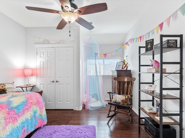 bedroom with a closet, wood finished floors, visible vents, vaulted ceiling, and ceiling fan