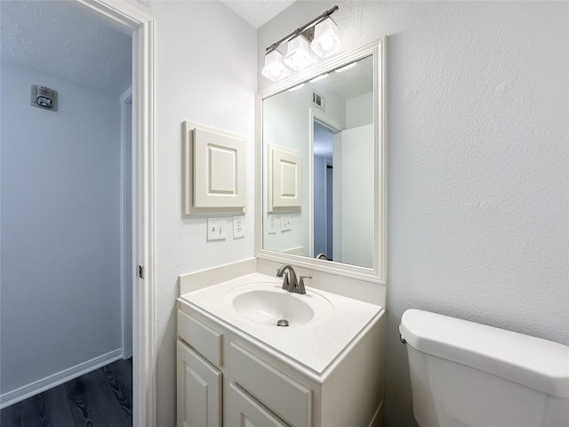 8051 Bay Branch Dr Unit 131, The Woodlands, TX 77382 - half bathroom with toilet, visible vents, wood finished floors, and vanity