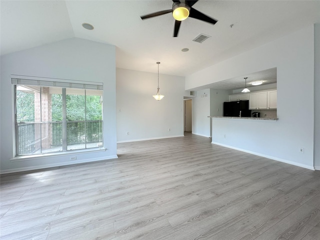8051 Bay Branch Dr Unit 131, The Woodlands, TX 77382 - unfurnished living room featuring lofted ceiling, baseboards, light wood finished floors, ceiling fan, and visible vents