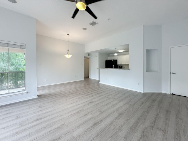 8051 Bay Branch Dr Unit 131, The Woodlands, TX 77382 - unfurnished living room featuring baseboards, visible vents, light wood-style flooring, and a ceiling fan