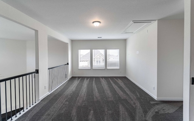 8406 Crab Blossom Dr, Cypress, TX 77433 - spare room featuring attic access, a textured ceiling, baseboards, and dark carpet