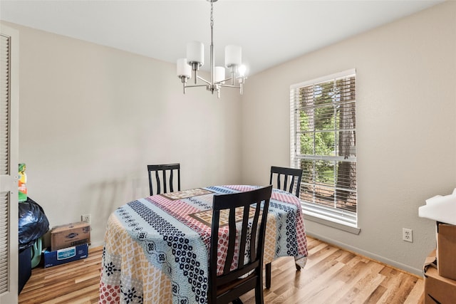 dining area featuring wood finished floors and a notable chandelier