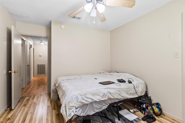 bedroom featuring ceiling fan, visible vents, and light wood-style floors
