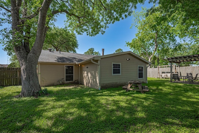 rear view of property featuring a pergola, a fenced backyard, and a yard