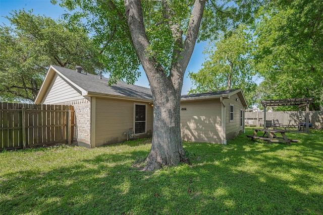back of property with a pergola, a lawn, and a fenced backyard