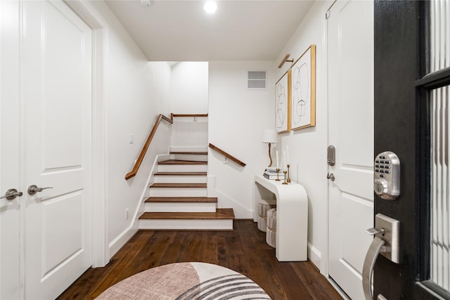 foyer featuring baseboards, stairs, visible vents, and hardwood / wood-style flooring