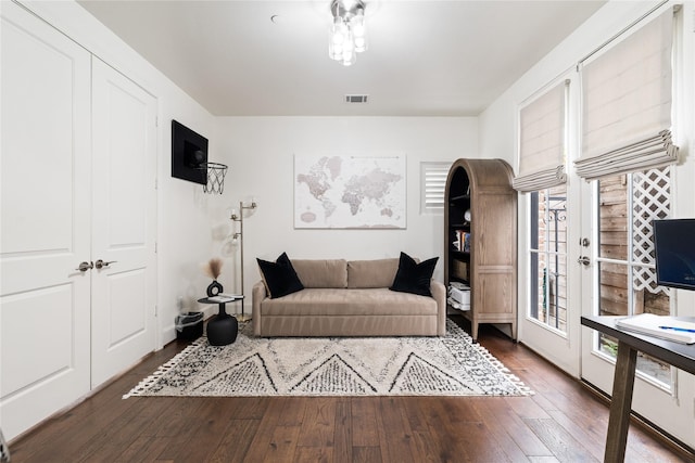 living area featuring wood-type flooring, baseboards, and visible vents