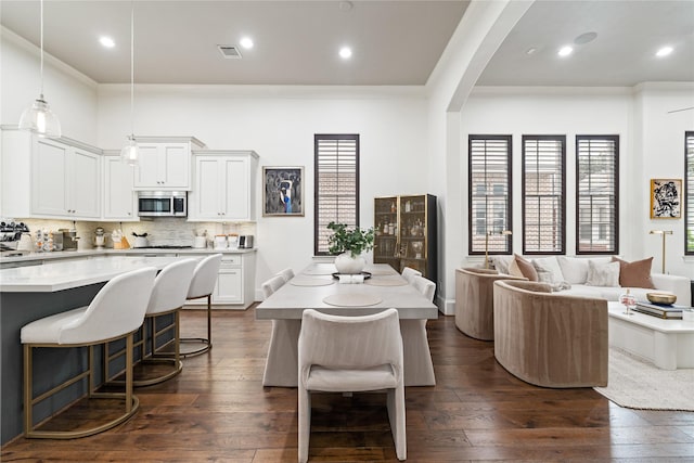 dining area with crown molding, visible vents, arched walkways, dark wood-style floors, and recessed lighting