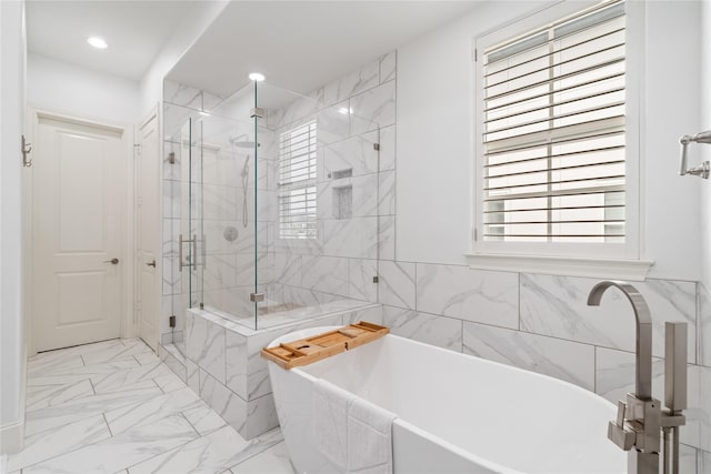 bathroom featuring a freestanding bath, plenty of natural light, and a shower stall