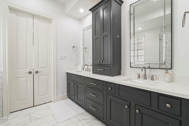bathroom featuring recessed lighting, double vanity, marble finish floor, and a sink