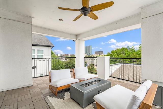 balcony featuring ceiling fan and a fire pit