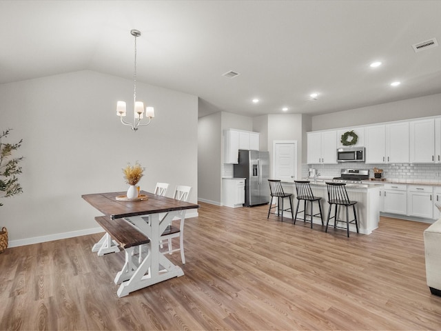 dining room with a notable chandelier, light wood-style floors, visible vents, and recessed lighting