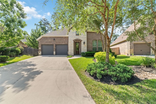 145 Lily Green Ct, Conroe, TX 77304 - view of front of house with brick siding, driveway, a garage, and stone siding