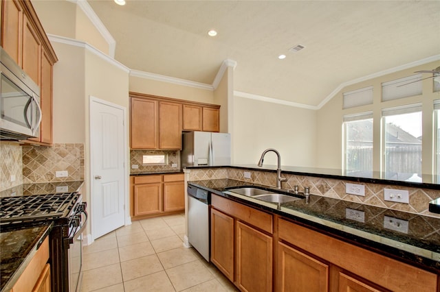 8523 Dolan Heights Ct, Cypress, TX 77433 - kitchen featuring a sink, vaulted ceiling, brown cabinets, and appliances with stainless steel finishes