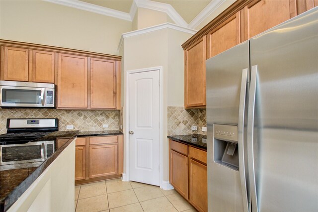 8523 Dolan Heights Ct, Cypress, TX 77433 - kitchen featuring dark stone counters, ornamental molding, light tile patterned flooring, decorative backsplash, and appliances with stainless steel finishes
