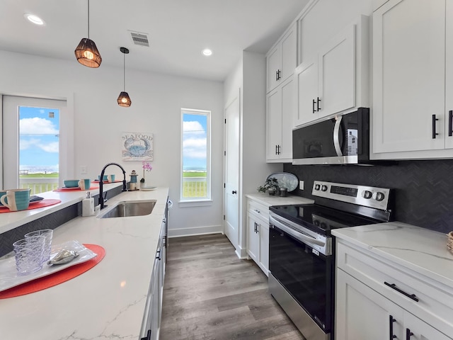 525 Annabelle Dr, Gilchrist, TX 77617 - kitchen with plenty of natural light, visible vents, a sink, wood finished floors, and appliances with stainless steel finishes