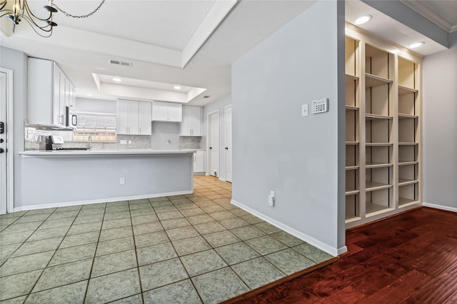 6615 Cypress Village Dr, Sugar Land, TX 77479 - kitchen with a peninsula, white cabinets, baseboards, light countertops, and a chandelier