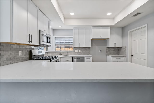 6615 Cypress Village Dr, Sugar Land, TX 77479 - kitchen with a sink, visible vents, white cabinetry, decorative backsplash, and appliances with stainless steel finishes