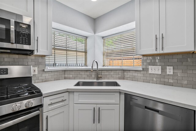 6615 Cypress Village Dr, Sugar Land, TX 77479 - kitchen featuring light countertops, appliances with stainless steel finishes, white cabinetry, and a sink
