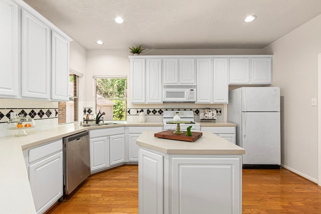 6811 S Trace Dr, Magnolia, TX 77354 - kitchen with white appliances, white cabinets, recessed lighting, and a sink