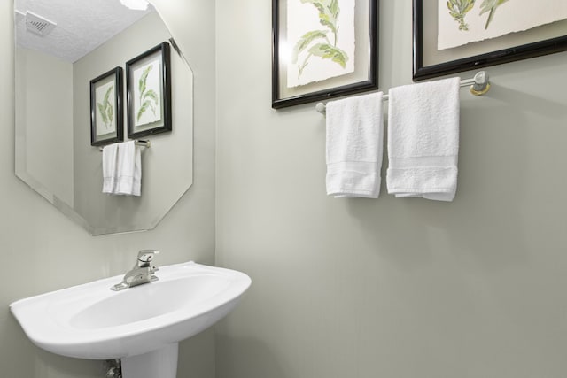 6811 S Trace Dr, Magnolia, TX 77354 - bathroom with a textured ceiling, visible vents, and a sink