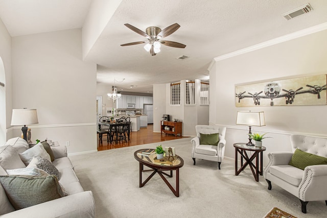 6811 S Trace Dr, Magnolia, TX 77354 - living room with carpet, ceiling fan with notable chandelier, visible vents, baseboards, and ornamental molding