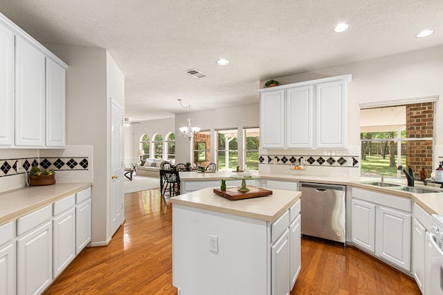 6811 S Trace Dr, Magnolia, TX 77354 - kitchen with a sink, a textured ceiling, stainless steel dishwasher, visible vents, and a chandelier