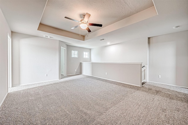 1339 Kane Ct, Rosenberg, TX 77471 - unfurnished room with a ceiling fan, a tray ceiling, a textured ceiling, baseboards, and carpet flooring