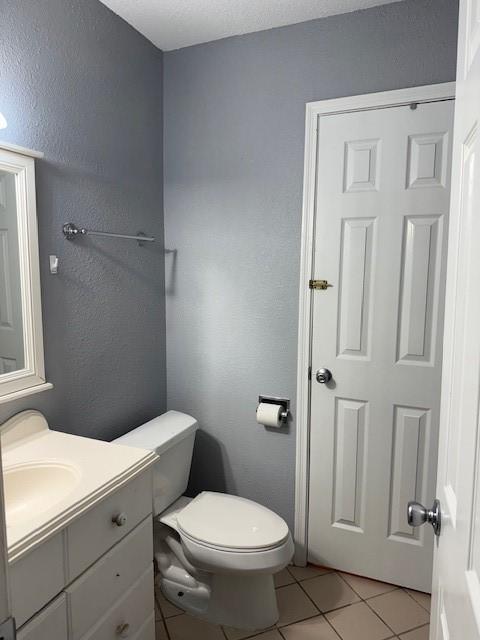 1101 E Brown Ln, Deer Park, TX 77536 - half bath with toilet, tile patterned flooring, vanity, and a textured wall