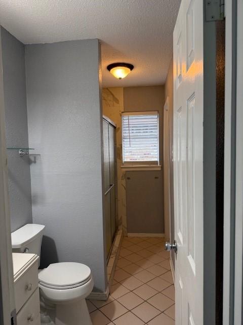 1101 E Brown Ln, Deer Park, TX 77536 - full bathroom with toilet, vanity, a textured ceiling, tile patterned floors, and a shower stall