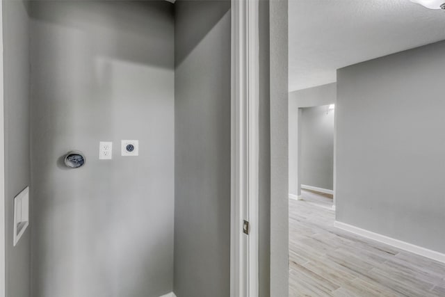 laundry room with laundry area, electric dryer hookup, baseboards, and light wood finished floors