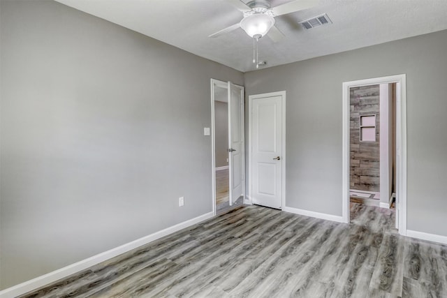 unfurnished bedroom featuring light wood-type flooring, ceiling fan, baseboards, and visible vents