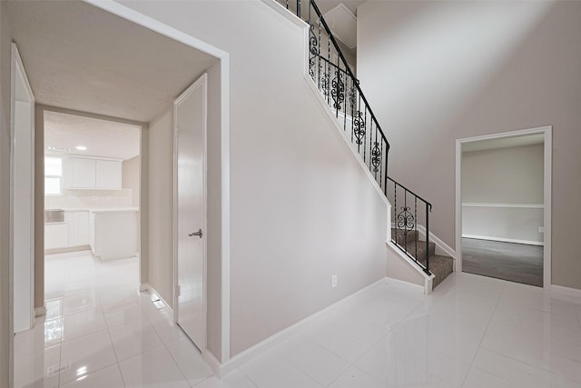 staircase featuring tile patterned floors and baseboards