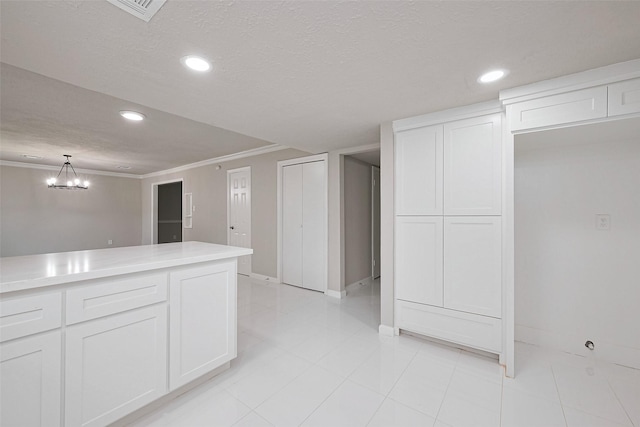 kitchen with ornamental molding, recessed lighting, light countertops, white cabinets, and baseboards