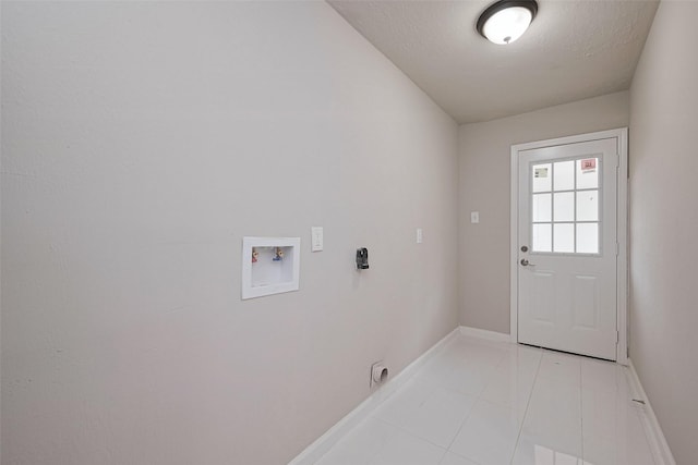 clothes washing area with light tile patterned floors, electric dryer hookup, laundry area, washer hookup, and baseboards