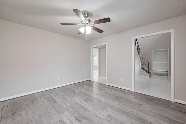 unfurnished bedroom featuring baseboards, a textured ceiling, a ceiling fan, and wood finished floors
