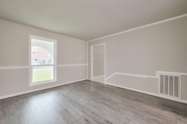 spare room featuring visible vents, wood finished floors, and baseboards