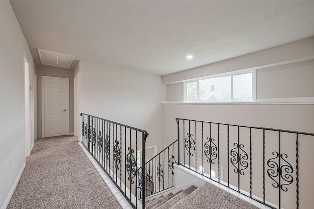 hallway with attic access, an upstairs landing, recessed lighting, carpet floors, and baseboards