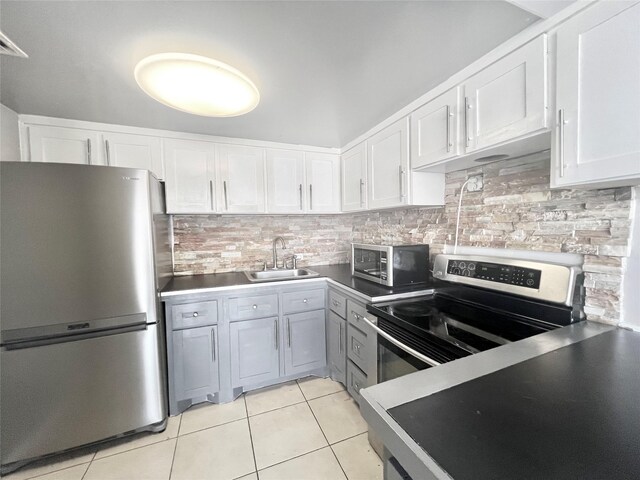 kitchen featuring light tile patterned floors, stainless steel appliances, tasteful backsplash, and a sink